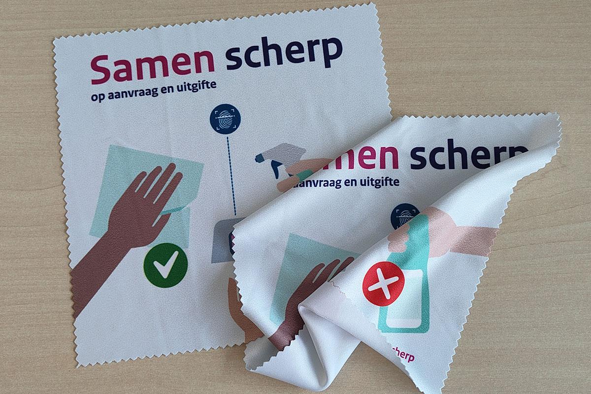 Twee poetsdoekjes van samen scherp. Op het doekje is een hand te zien die schoonmaakt