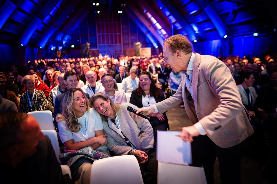 Presentator stelt vraag aan zaal vol mensen